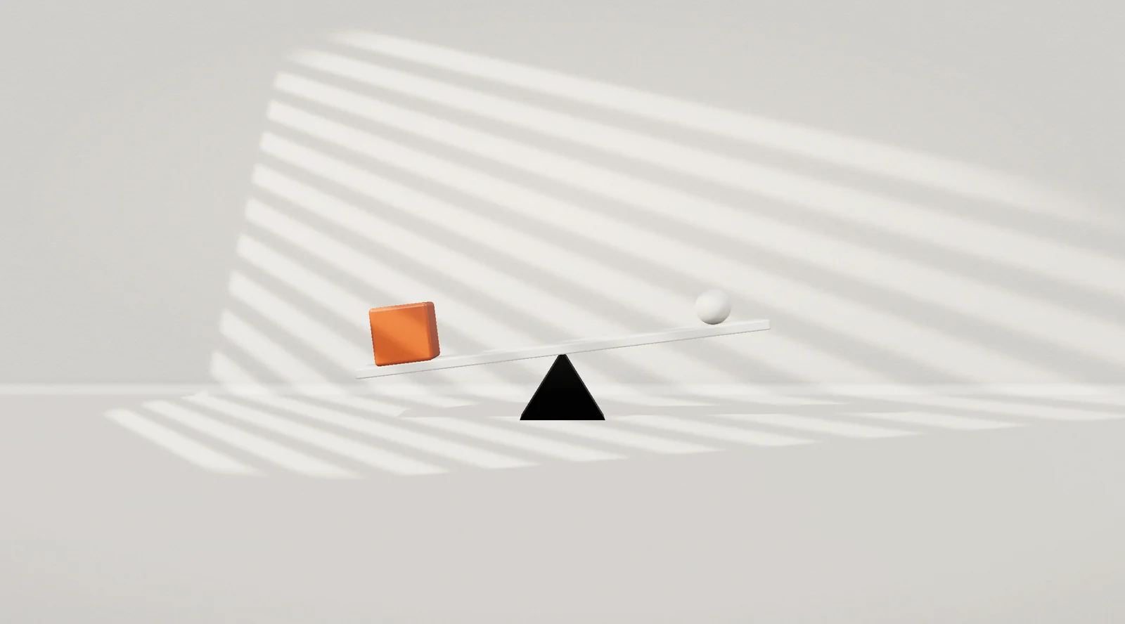 A cube and a ball balanced on a seesaw